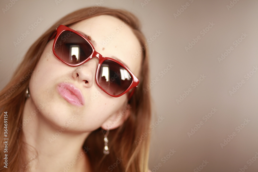 Naklejka premium Girl in glasses. Girl portrait in red glasses. Beautiful young curious woman. Woman watching.