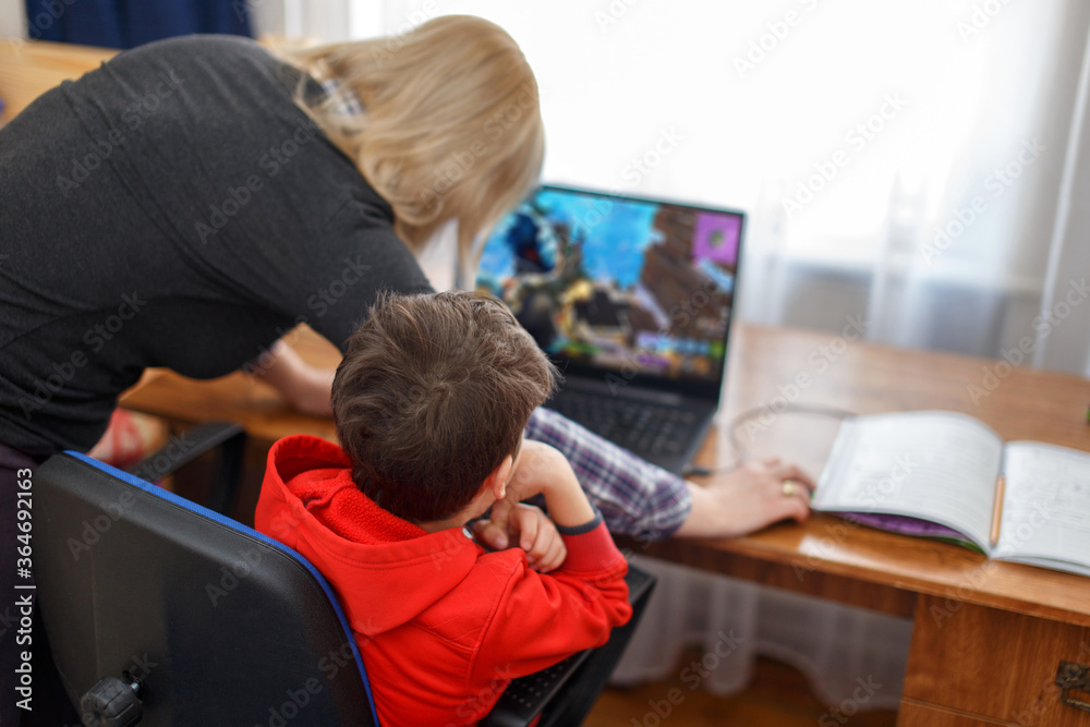 Obraz premium Mother turning off computer for computer addicted little gamer kid