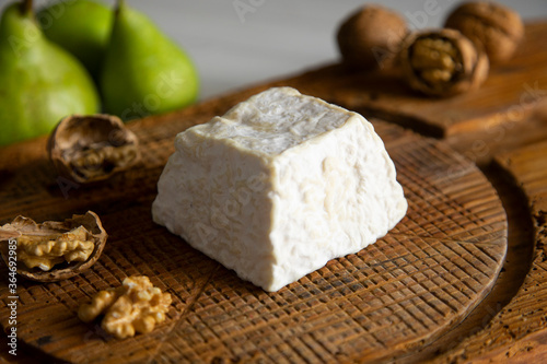 Premium organic goat cheese  on a rustic wooden cheese maker.