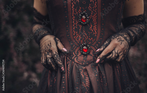 details of a Victorian dress: corset with black lace and lace gloves