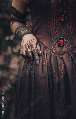 details of a Victorian dress: corset with black lace and lace gloves