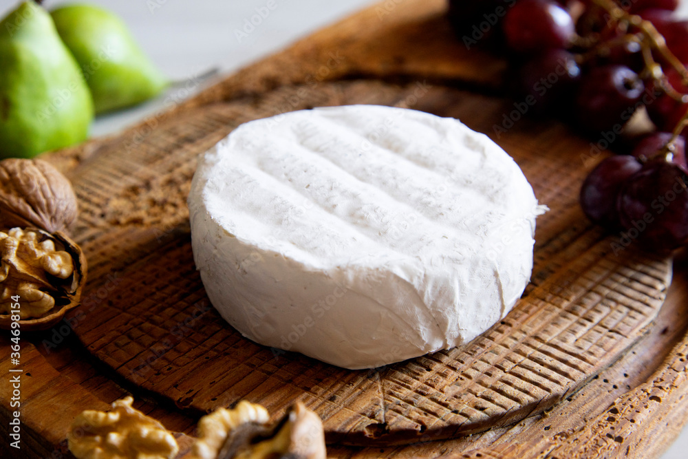Premium organic goat cheese on a rustic wooden cheese maker. Premium organic goat cheese on a rustic wooden cheese maker.
