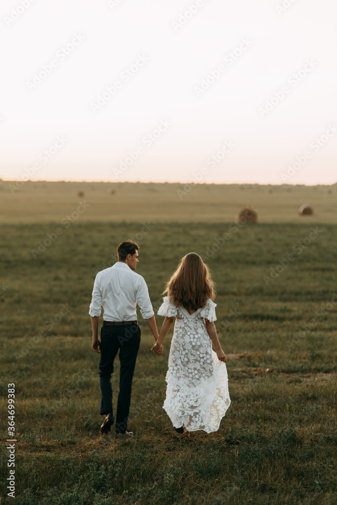 Beautiful couple in nature in boho style. Wedding in European style fine art at sunset.