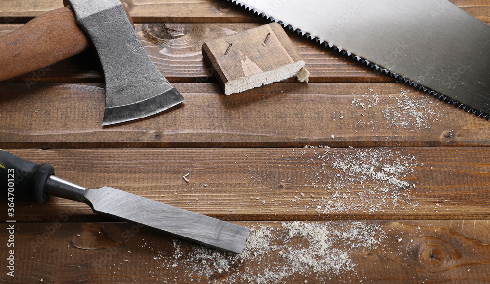 Tools for manual labor, handsaw, ax and spatula with sawdust on wood planks, wooden table surface background and texture Tools for manual labor, handsaw, ax and spatula with sawdust on wood planks, wooden table surface background and texture