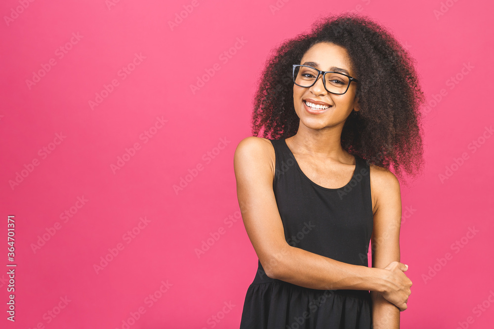 Portrait of beautiful positive african american black woman standing isolated over pink background.