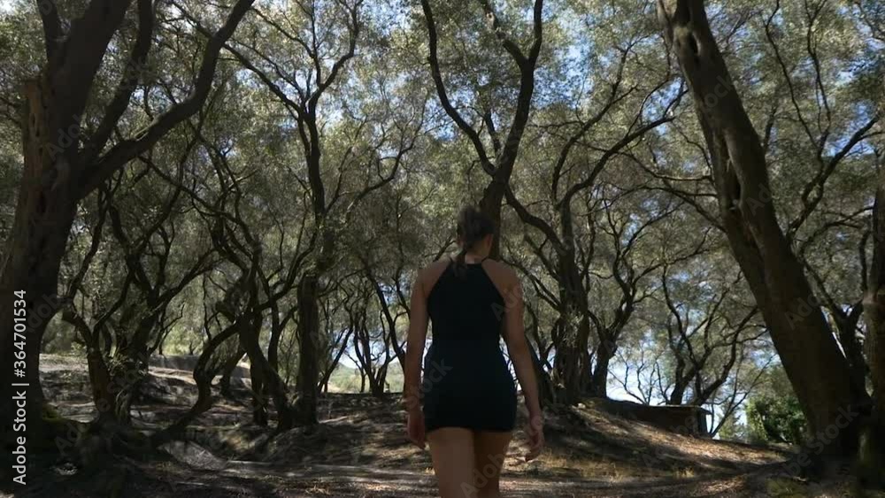 Beautiful Woman walking in Garden with Olive Trees Beautiful Woman walking in Garden with Olive Trees