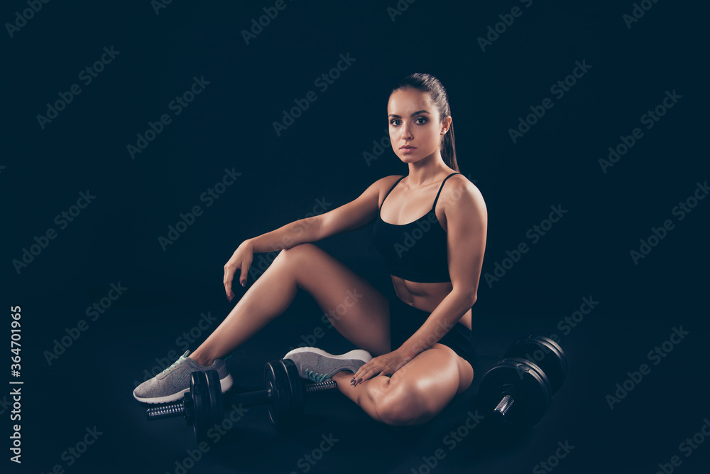 Obraz premium Portrait of concentrated lady sit wear sneakers hair brunette isolated over black background