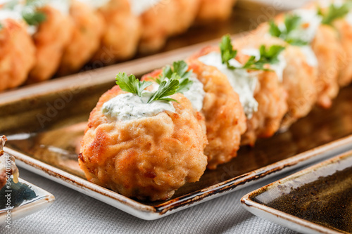 Принти на полотні Delicious appetizers with deep fried meat with sauce and herbs on plate over banquet table