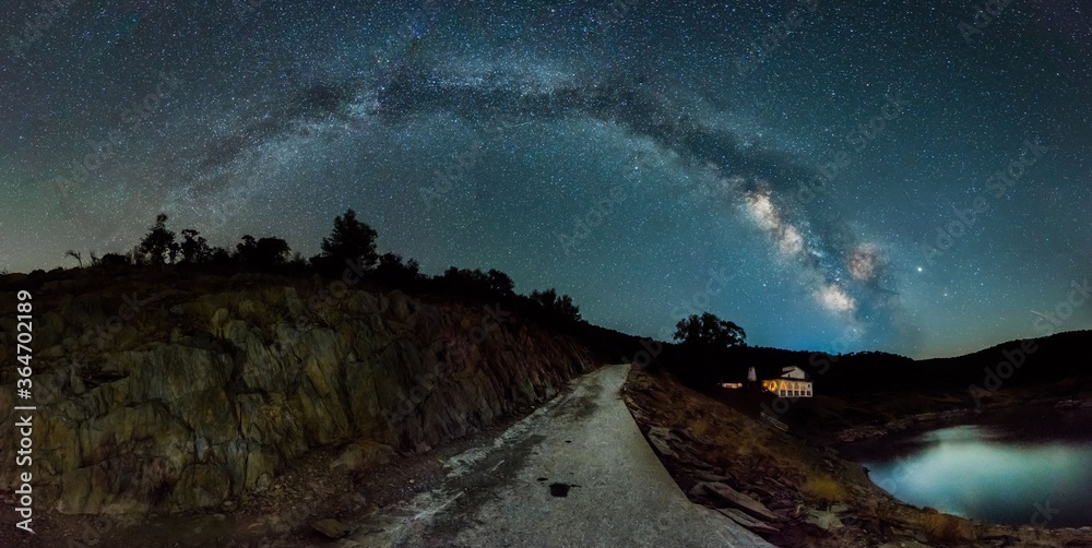 night photograph of the milky way on a river with a hermitage in the background