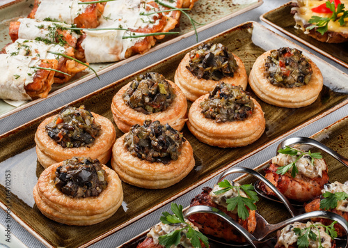 Delicious appetizers in tart with grilled vegetables in plate on banquet table. Catering food, canape and snacks