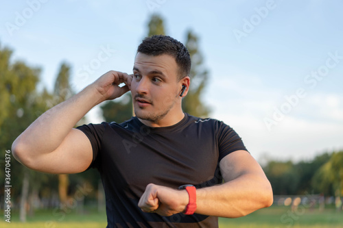 Technology for sport and active living. Athlete man talking into smartwatch wearable tech device speaking to someone or dictating message on smart watch app. © Aleksandar