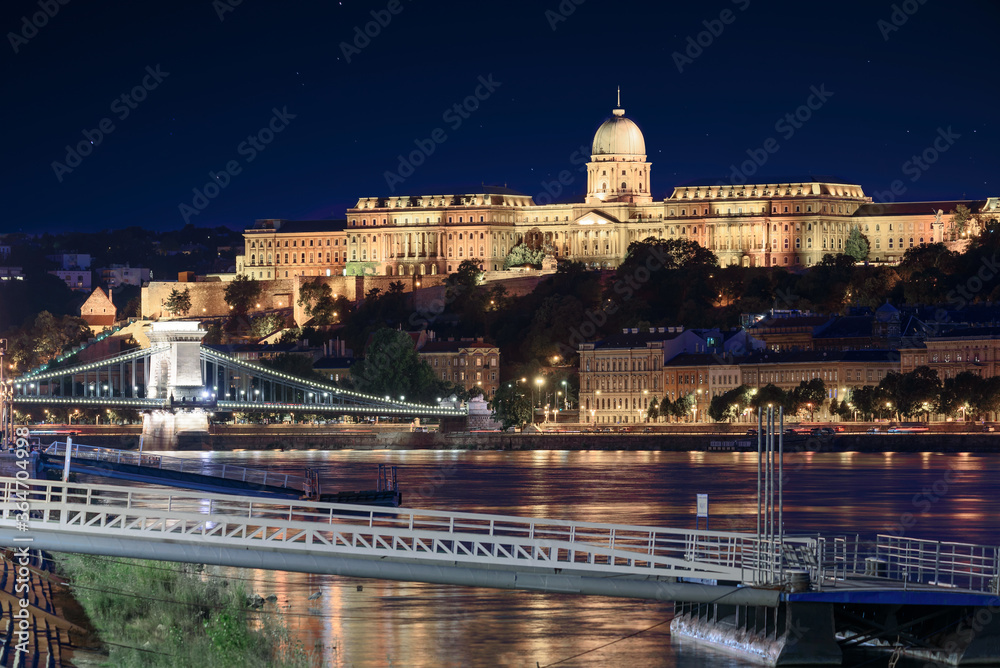 Night cityscape about Budapest Hungary. Boat dock Danube river Szechenyi Chain bridge and Buda royal castle in this picture.