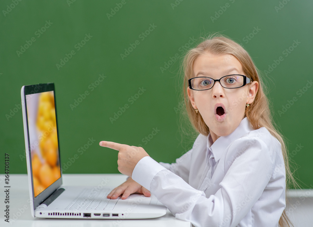 Shocked girl points on screen of the laptop. Internet safety concept ...