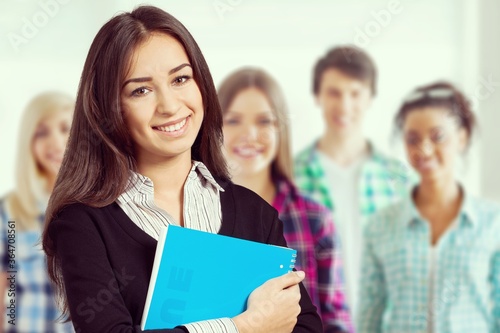 Young smiling woman holding blue notebook