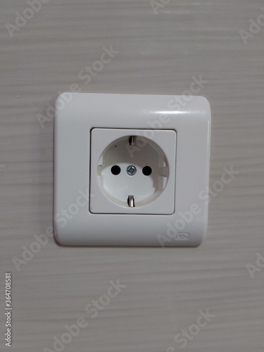 Very powerful white colored household electricity plug at home on an embedded wall.