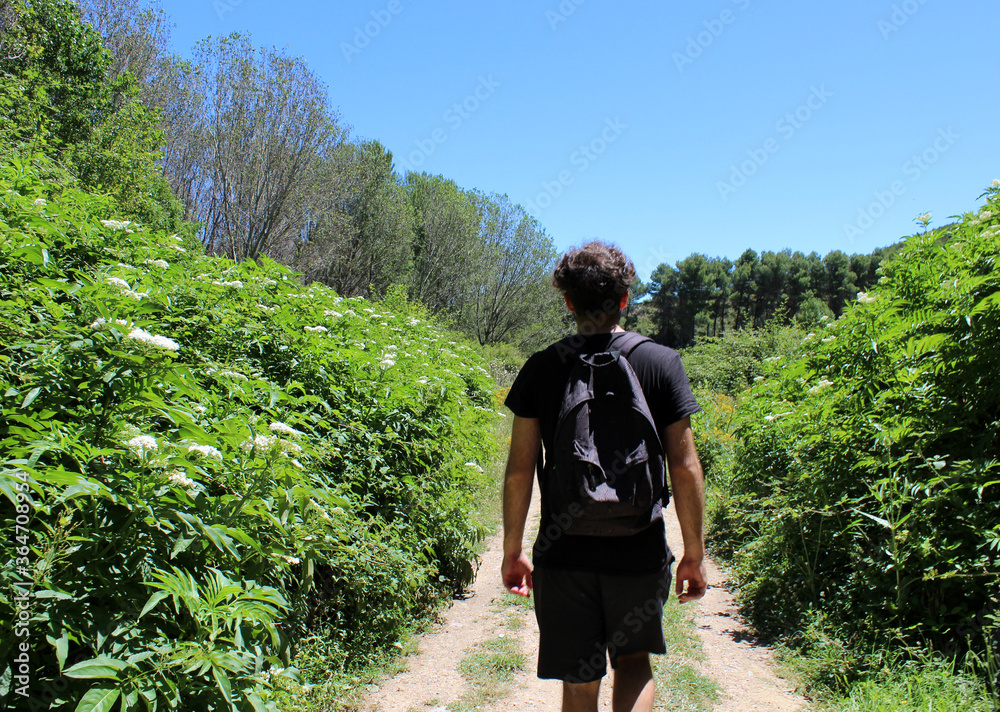 Young man walking and hiking up the mountain Young man walking and hiking up the mountain