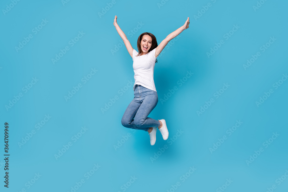 Full length body size view of her she attractive lovely slim skinny glad lucky cheerful cheery girl jumping rising hands up having fun holiday isolated bright vivid shine vibrant blue color background