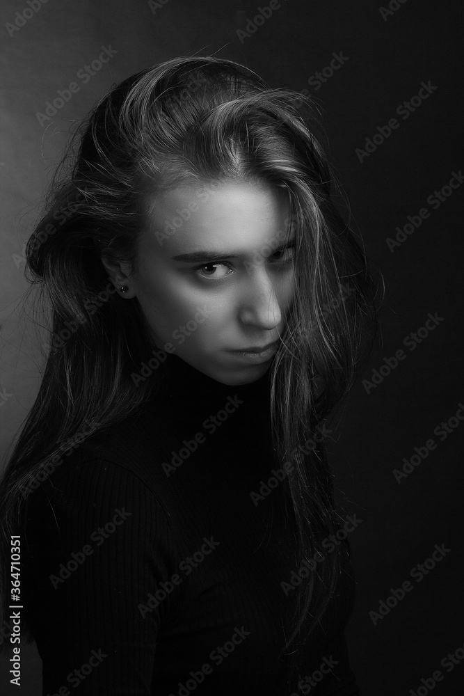 A young woman with disheveled hair. Black-and-white dramatic portrait. A young woman with disheveled hair. Black-and-white dramatic portrait.