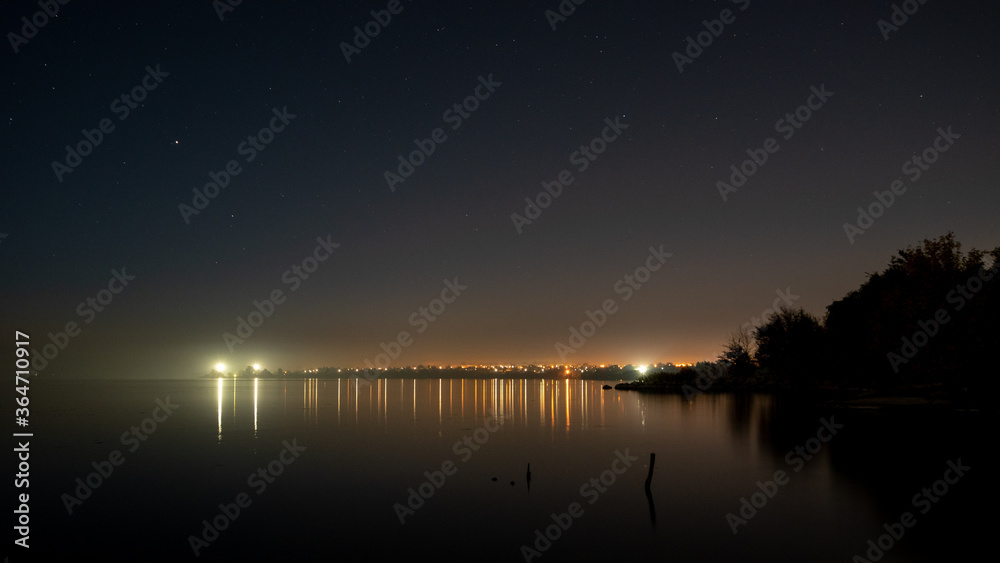 night city in the reflection of the waters with the starry sky