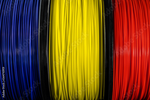 Romania flag of the coils for 3D printer. Filament for 3d printing. Bright thermoplastic of blue, yellow and red colors.