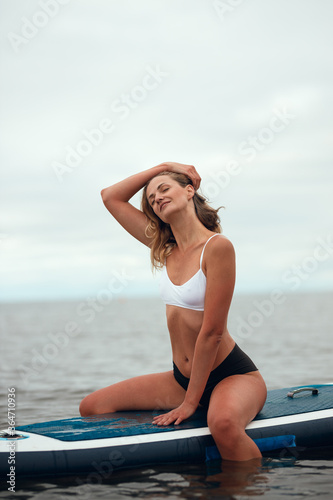 Woman practicing yoga on the paddle board in the morning © toxicoz