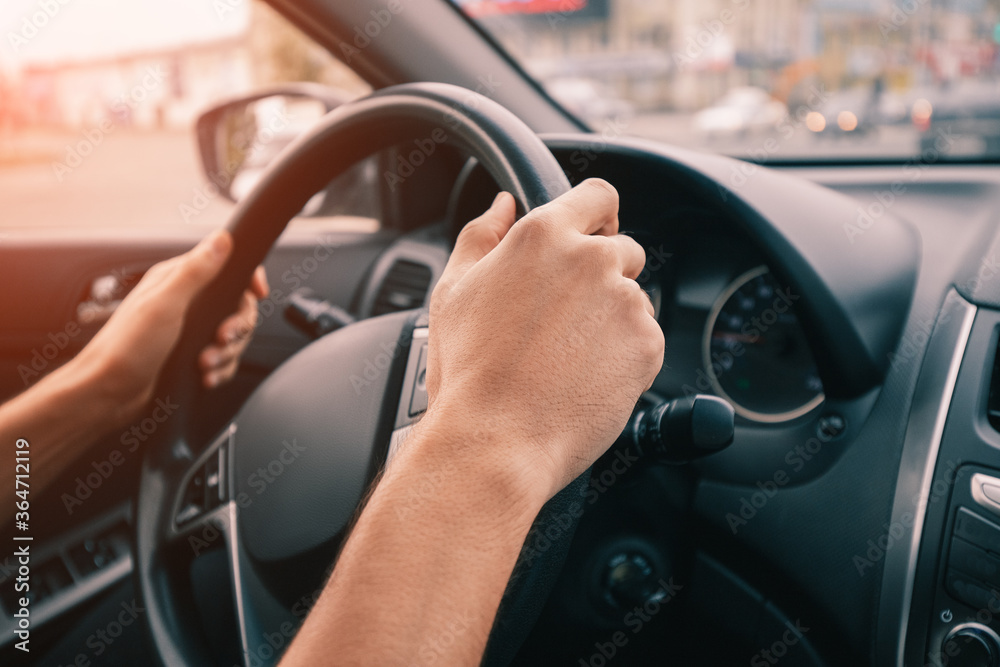 driver keeps his hands firmly on the steering wheel in his car. The concept of learning to drive and safe on the road driver keeps his hands firmly on the steering wheel in his car. The concept of learning to drive and safe on the road