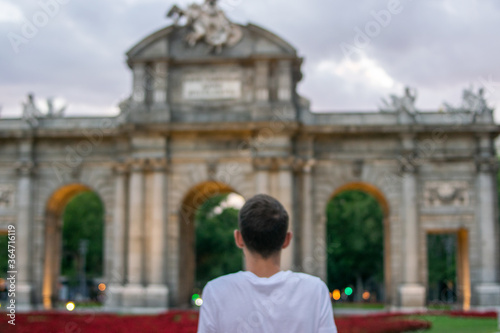 Madrid, Spain / July 13 2020 / Photo of an attractive guy next to Alcala gate in Madrid during sunset	
