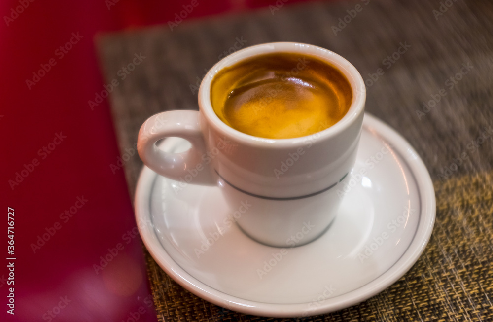 Close up beautiful white coffee cup with foam of morning, breakfast espresso with latte art on the black vintage red table Dark black and white space background Trendy toning Hot Latte Art coffee