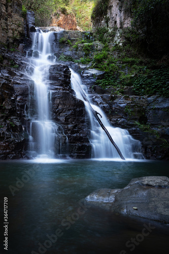 Fototapeta Naklejka Na Ścianę i Meble -  Waterfall tumbling over a ledge into a beautiful swimming hole below