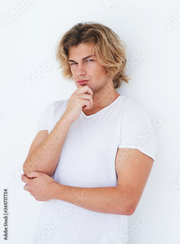 Young man, fashion model posing in a white t-shirt, casual style