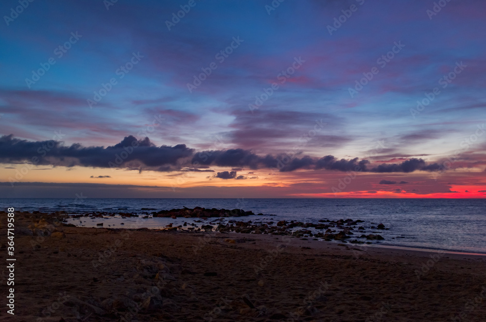 Obraz premium Scenic colorful sunset at the sea coast. Good for wallpaper or background image Radiant sea beach sunset Panoramic photo .Sunset sea horizon sky clouds. Sea sand beach 