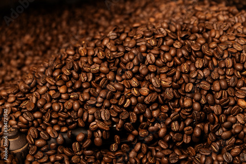 Fresh Roasted Natural Coffee Beans Cascading out of Industrial Coffee Bean Roaster Machine Inside the Coffee Shop