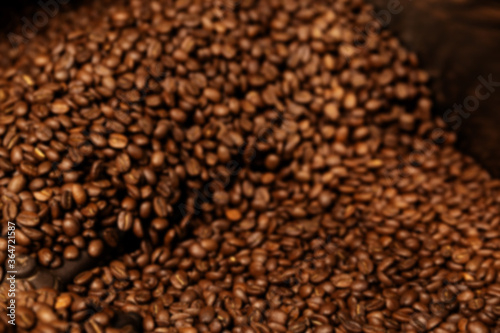 Blured Photo. Fresh Roasted Natural Coffee Beans Cascading out of Industrial Coffee Bean Roaster Machine Inside the Coffee Shop