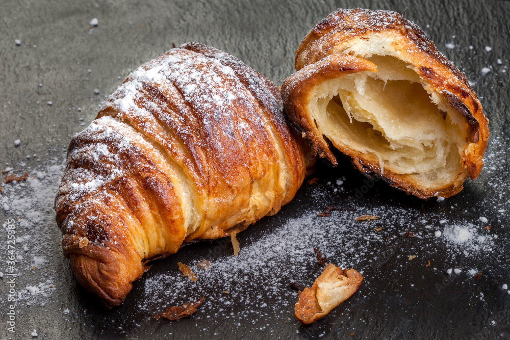 French croissant Freshly baked croissants with jam on a dark stone background. Tasty croissants with copy space