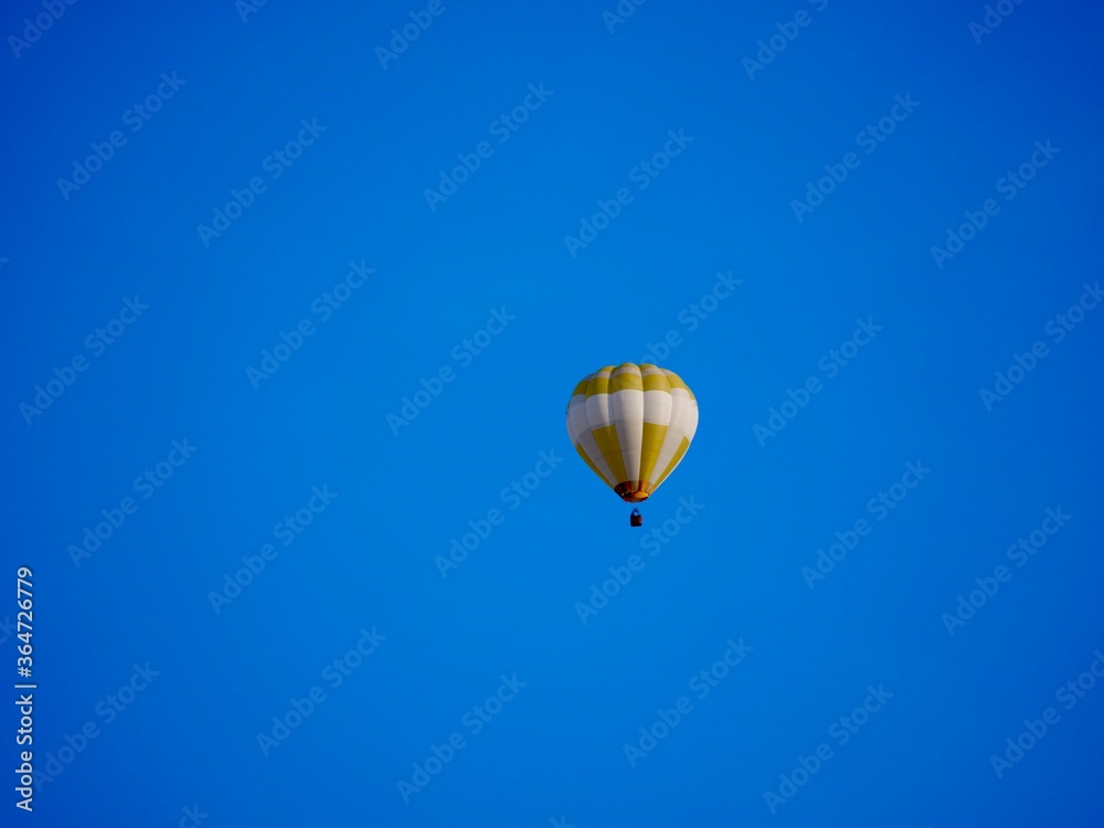 Obraz premium balloon flying mid-air in sunshine against blue sky