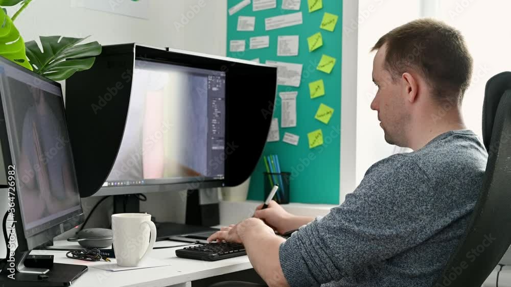 Work from home. Young male photographer processes photos on a computer at home. Work from home. Young male photographer processes photos on a computer at home.
