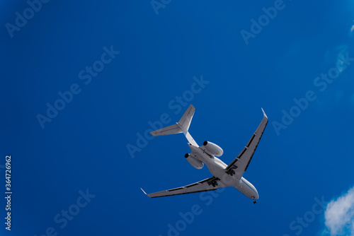 Flying plane against the blue sky. A white plane and an Indigo sky. Airliner before landing