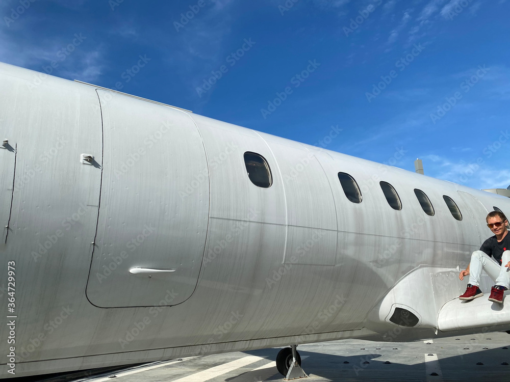 Obraz premium A man near a white plane. Blue sky. Journeys.