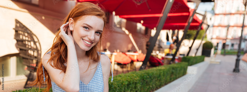 Lovely redhead girl holding notepad and a pen