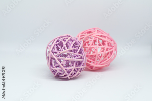 Dry reeds designed into two pink and lilac balls for decoration on white background.