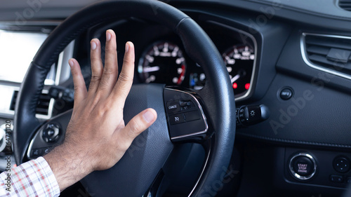 man pushing horn while driving sitting of a steering wheel press car, honking sound to warn other people in traffic concept.