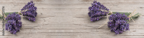 Many bouguet of violet purple lavendula lavender flowers herbs on old rustic wooden table  wood background banner panoramic panorama long  close up