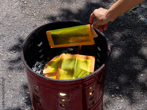 Gold Chinese joss paper being burnt for ancestral worship or prayer