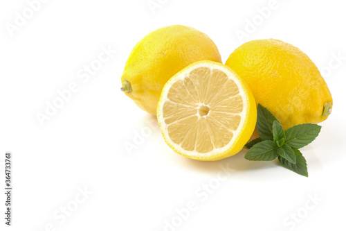 lemons whole and sliced, mint leaves, close-up on a white background, text space, horizontal view