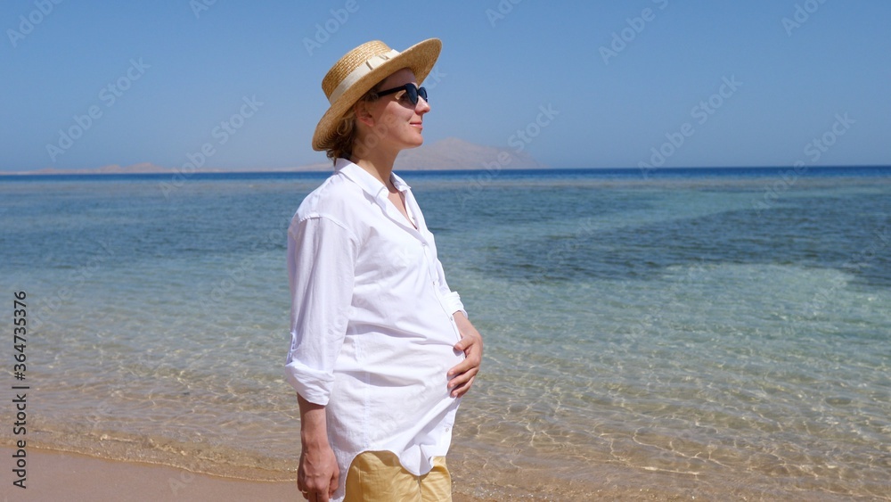 Young Pregnant Woman Walking At Sea Beach. Baby Expectation Concept.