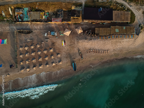 Aerial view of amazing beach with umbrellas and turquoise sea at sunrise. Black Sea at Vama Veche, Romania photo
