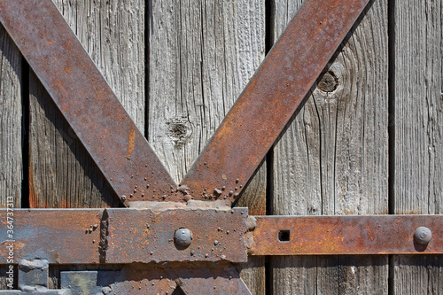 old wooden gates with rusty steel fittings, texture of rusty steel and wood