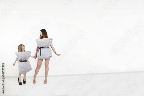 Mother and daughter are in the pillowdresses on the white background. Cool mother and little girl are in quarantine. pillow challenge photo