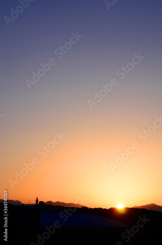 夕空と夜空のグラデーション、沈む夕日と大観音のシルエットのコントラスト