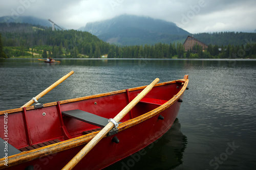 Fototapeta Naklejka Na Ścianę i Meble -  Boat with oars in the middle of a mountain lake close up.